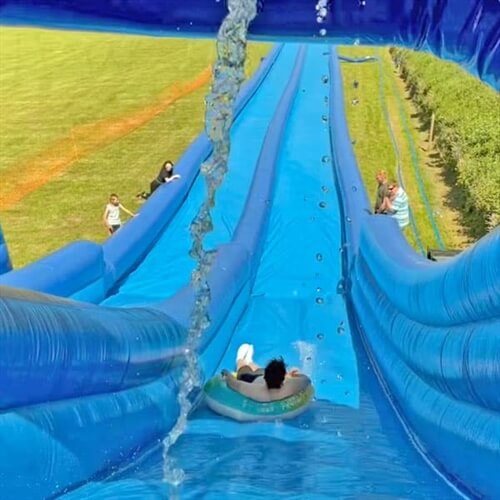 Slip n Slide Water Adventure Devon - Man Sliding Down on Rubber Ring Slip n Slide Water Adventure Devon - Man Sliding Down on Rubber Ring