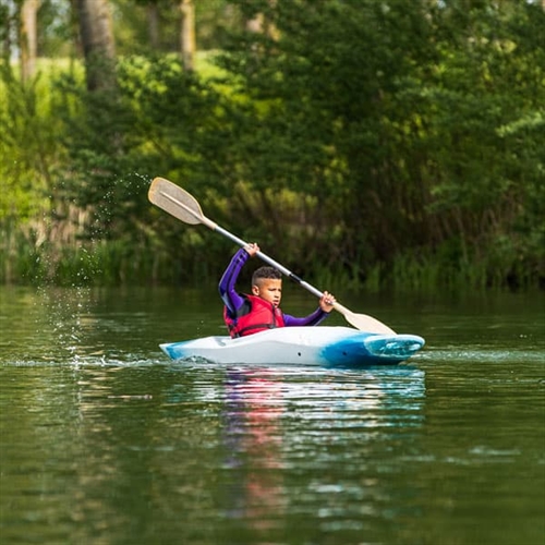 Boy paddling down river