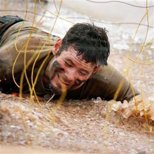 man crawling on assault course man crawling on assault course